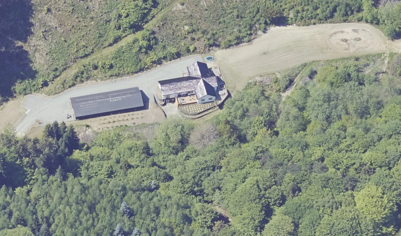 Nærbillede fra luften af hovedhus, terrasse og maskinhus